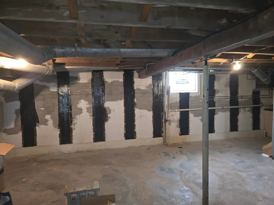Same basement after finishing: drywall, flooring, and lighting
